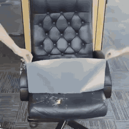 Chaise de bureau abîmée recouverte de cuir adhésif